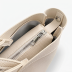 Beige handbag with a zipper on a light gray background
